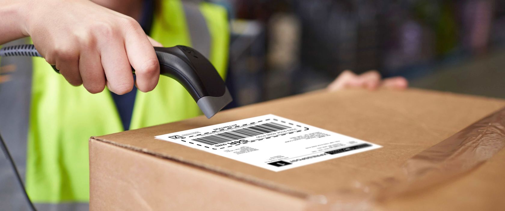 A postal worker scans the Canada Post shipping label on package
