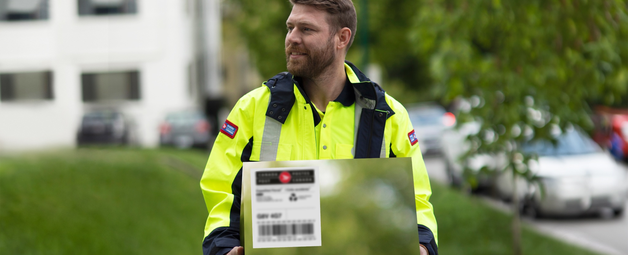 A Canada Post employee carries a carbon-neutral package for delivery.